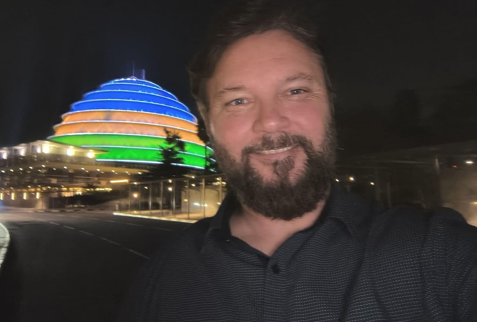 Daniel Homorodean of Arxia in Kigali, with the Kigali Convention Centre lit up at night.